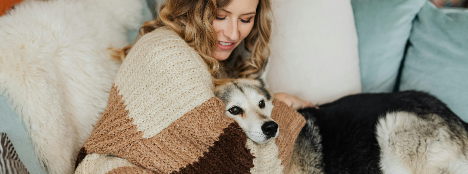 Ein Hund kuschelt mit seiner Besitzerin.